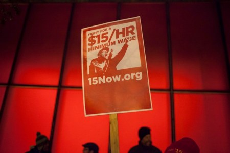 A protest sign is pictured during a rally to raise the hourly minimum wage to $15 for fast-food workers at City Hall in Seattle