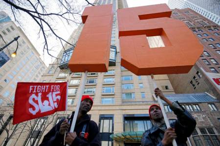 Demonstrators gather on the sidewalk with placards during a protest for a $15-an-hour nationwide minimum wage in downtown Chicago