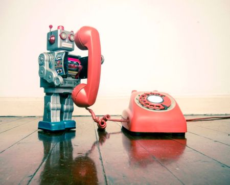 big silver robot toy on the phone standing on an old wooden floor t